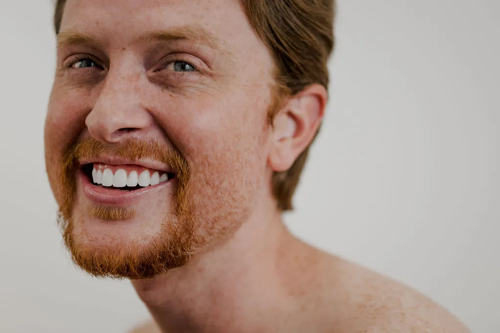 Patient Smiling After Receiving Porcelain Veneer Treatment at Pragma Dental